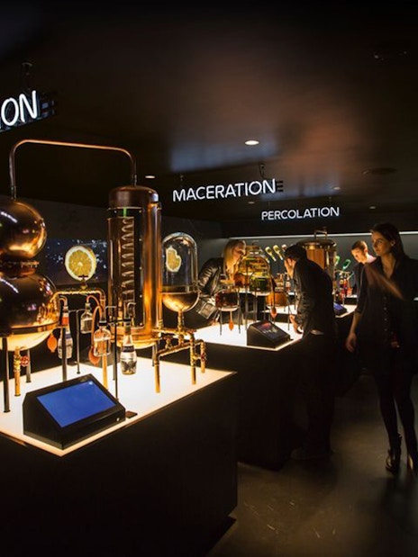 Visitors exploring distillation exhibits at Amsterdam House of Bols cocktail workshop.