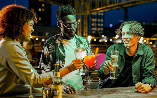 Group enjoying drinks on a rooftop bar during a safari tour evening.