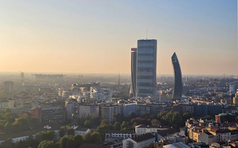 Milan skyline view with Torre Branca and modern skyscrapers at sunset.