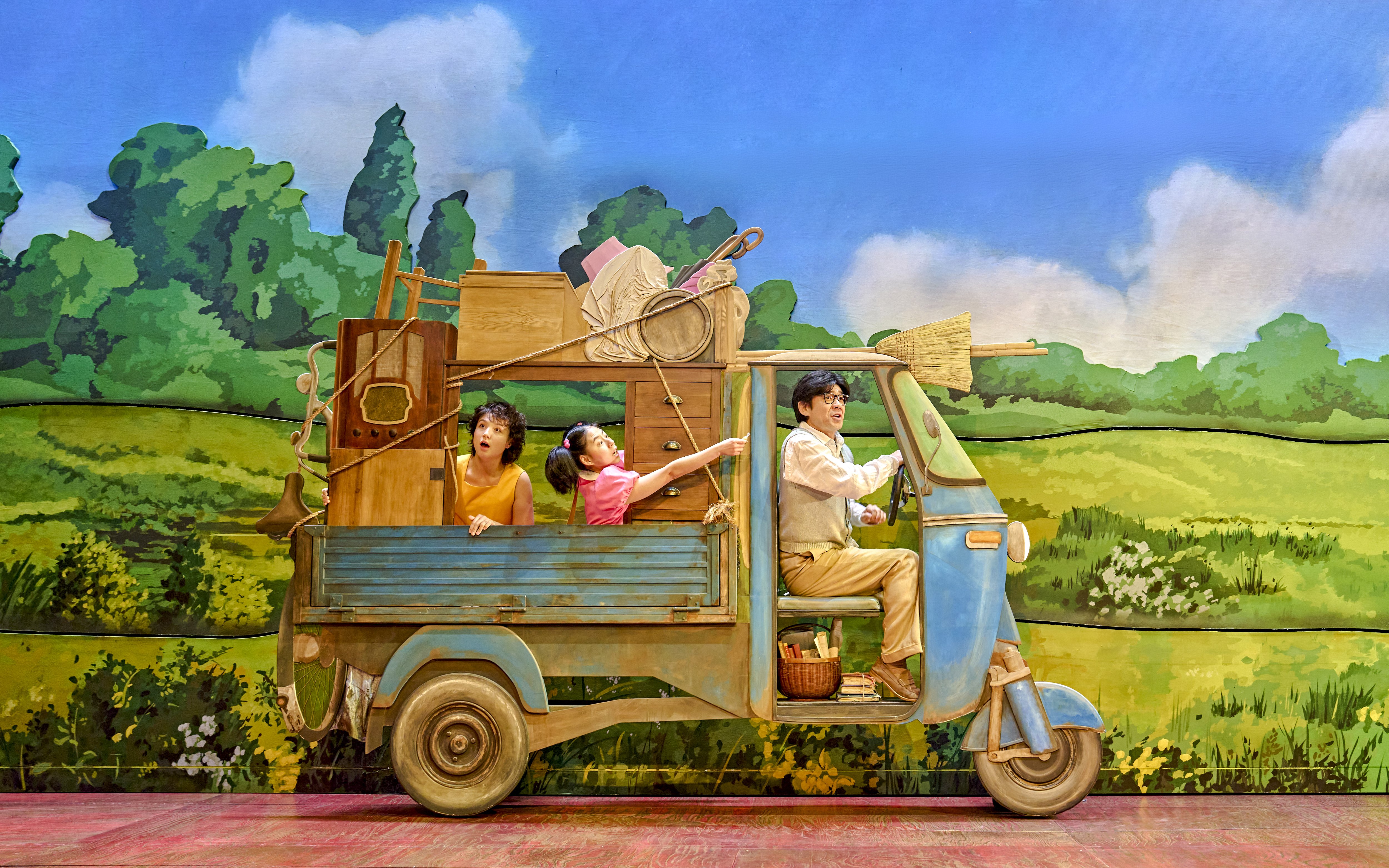 Family in a truck with household items, My Neighbour Totoro production scene.
