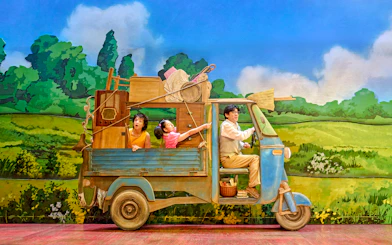 Family in a truck with household items, My Neighbour Totoro production scene.