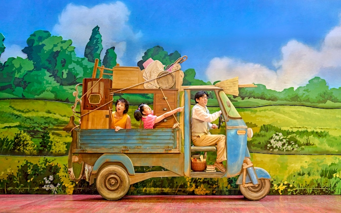 Family in a truck with household items, My Neighbour Totoro production scene.