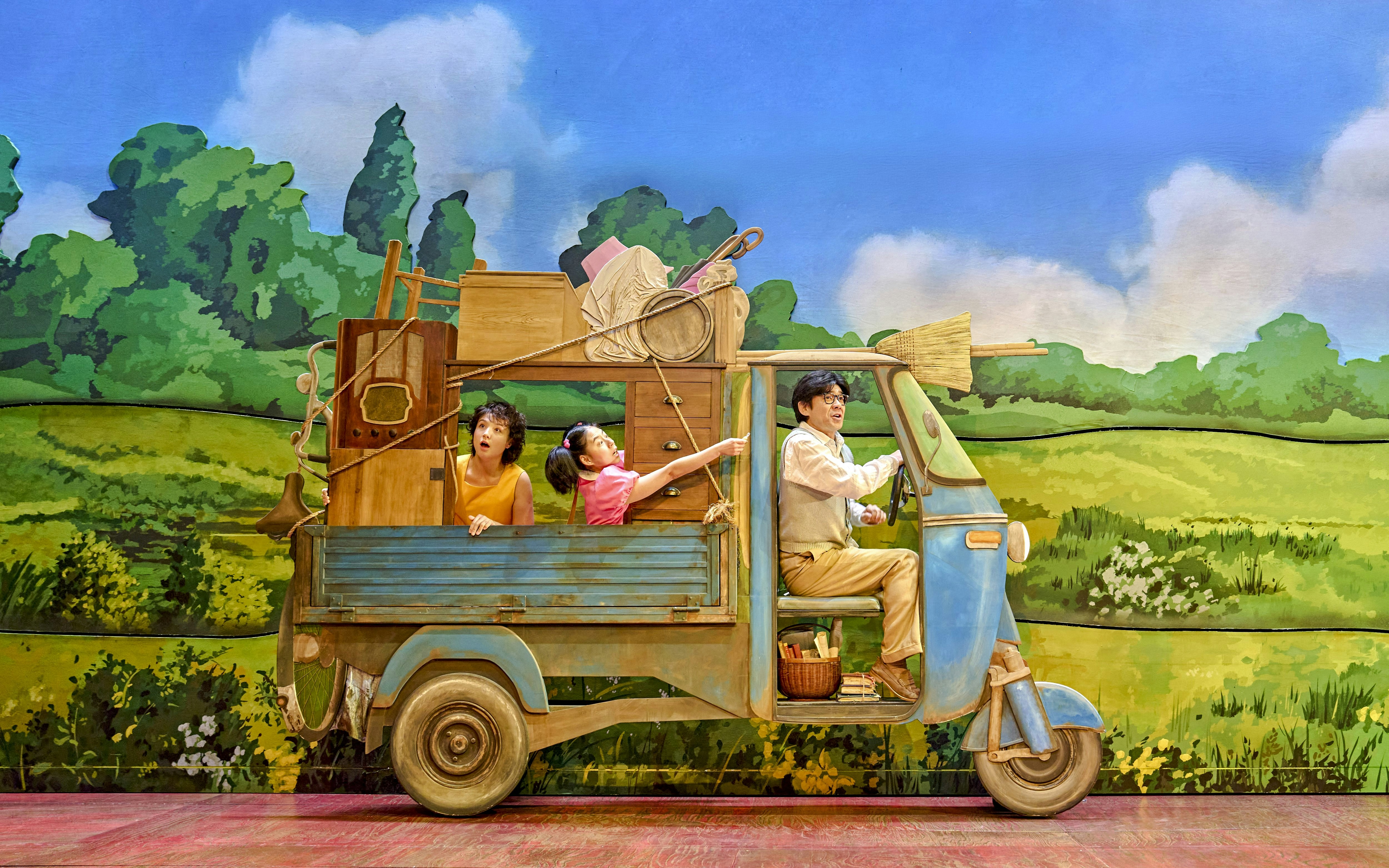 Family in a truck with household items, My Neighbour Totoro production scene.