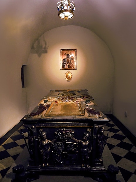 Crypt interior under Silver Bells Tower at Wawel Cathedral, featuring an ornate tomb.