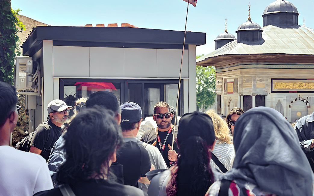 Tour guide leading a group near the Blue Mosque in Istanbul.