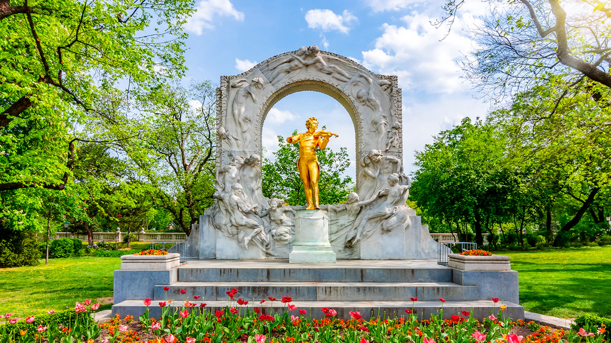 Johann Strauss monument surrounded by blooming flowers in Stadtpark, Vienna, Austria.