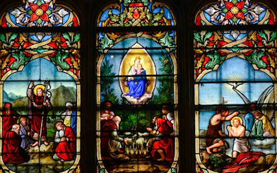 Stained glass window depicting religious scenes at Notre-Dame Cathedral, Paris.