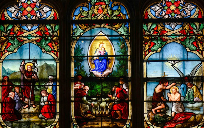 Stained glass window depicting religious scenes at Notre-Dame Cathedral, Paris.