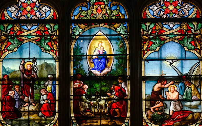 Stained glass window depicting religious scenes at Notre-Dame Cathedral, Paris.