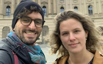 Two people smiling in front of a historic building in Berlin during a city exploration game.