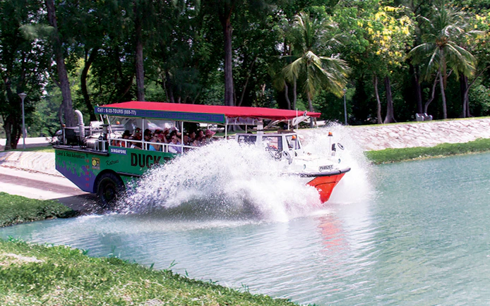 Amphibious vehicle splashing into water during DUCKtours Singapore.