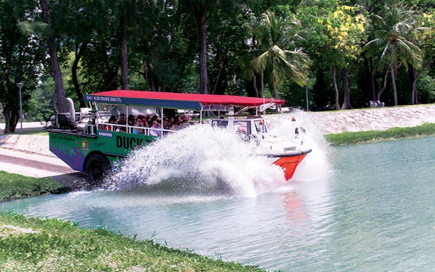 Amphibious vehicle splashing into water during DUCKtours Singapore.