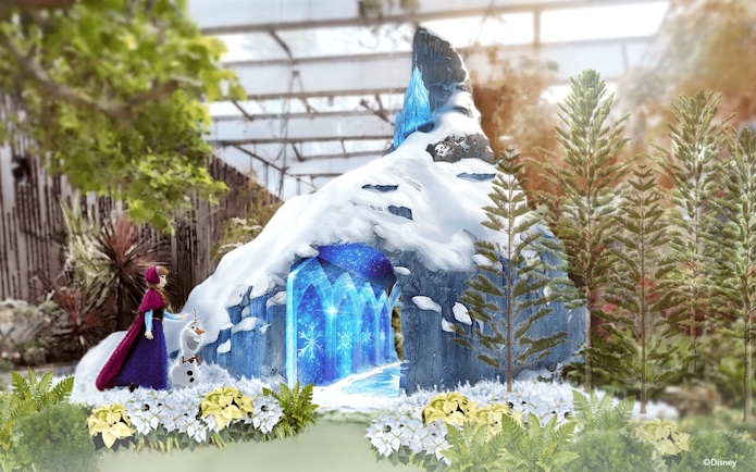 Anna and Olaf outside an icy cave with snowflakes in a winter garden setting.