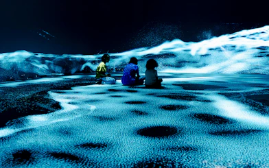 Children sitting in an immersive digital art display at the London Timewalk Exhibition.