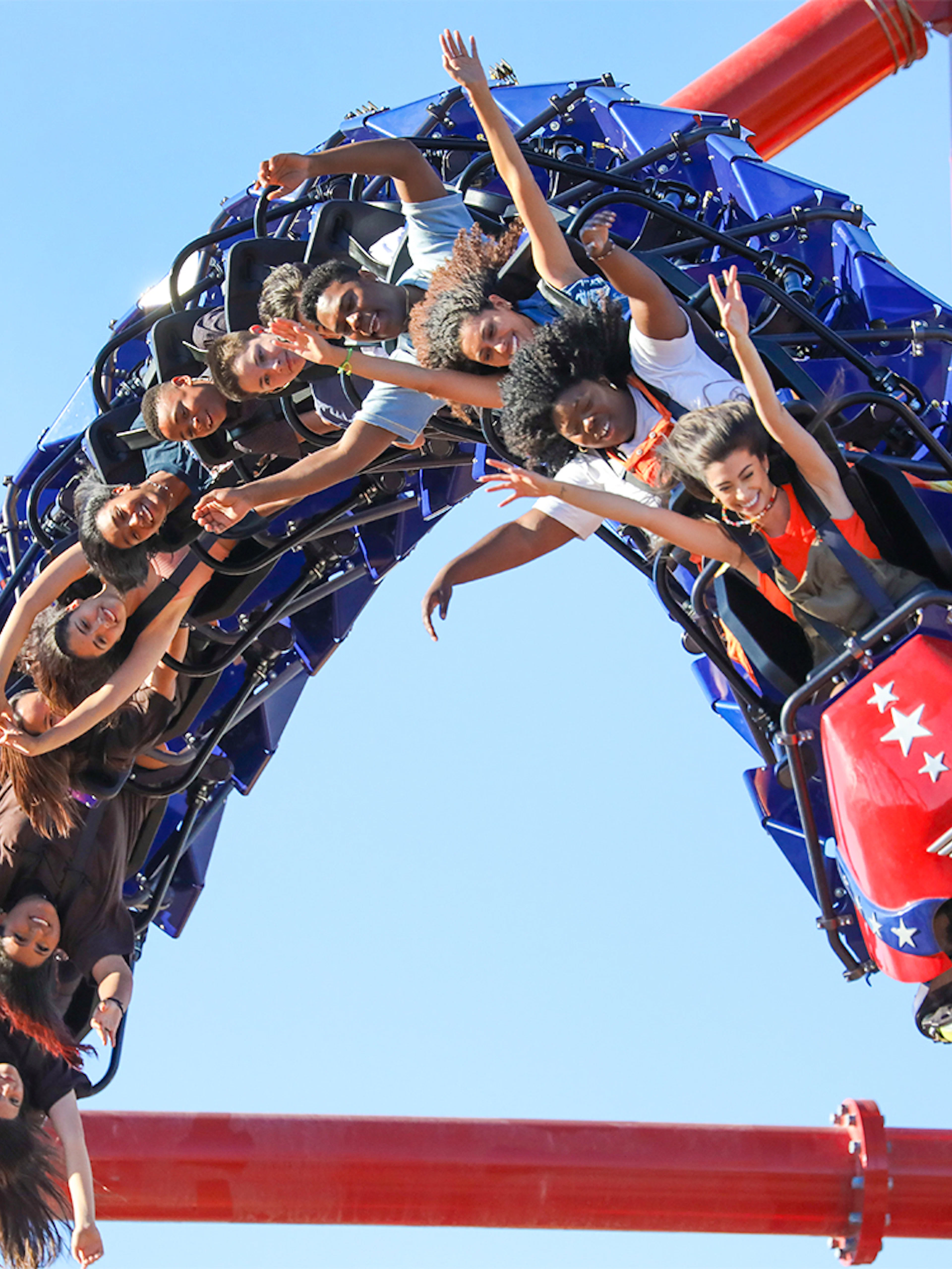 Riders on WONDER WOMAN™ Flight of Courage roller coaster at Six Flags Magic Mountain.