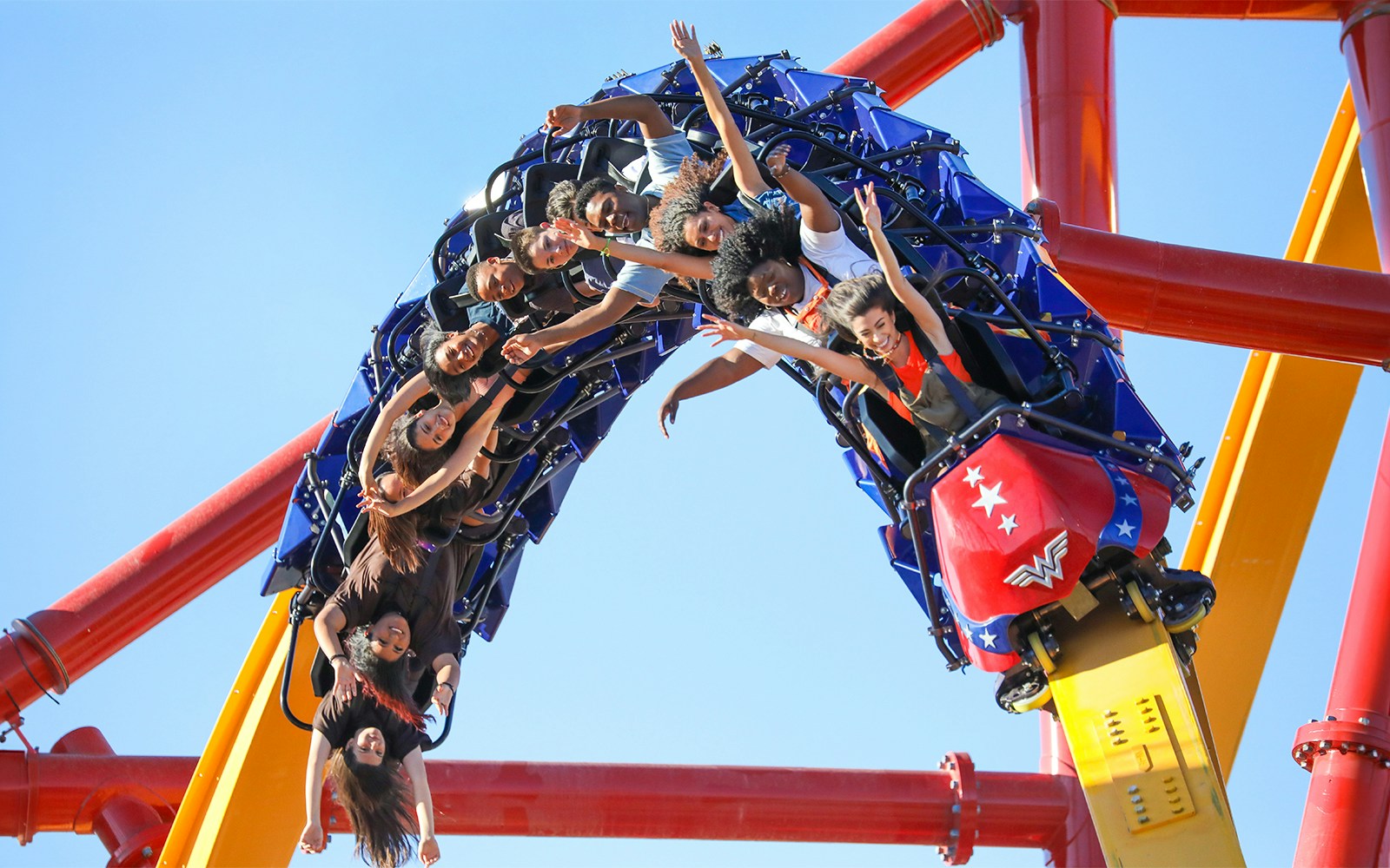 Riders on WONDER WOMAN™ Flight of Courage roller coaster at Six Flags Magic Mountain.