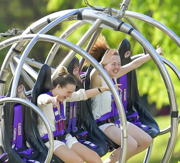 Slingshot ride in Singapore with city skyline in the background.
