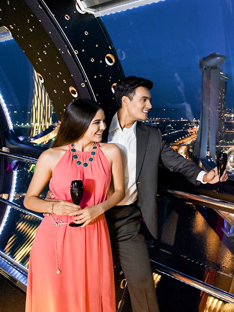 Couple enjoying champagne at 165 Sky Dining, Singapore Flyer with city skyline view.