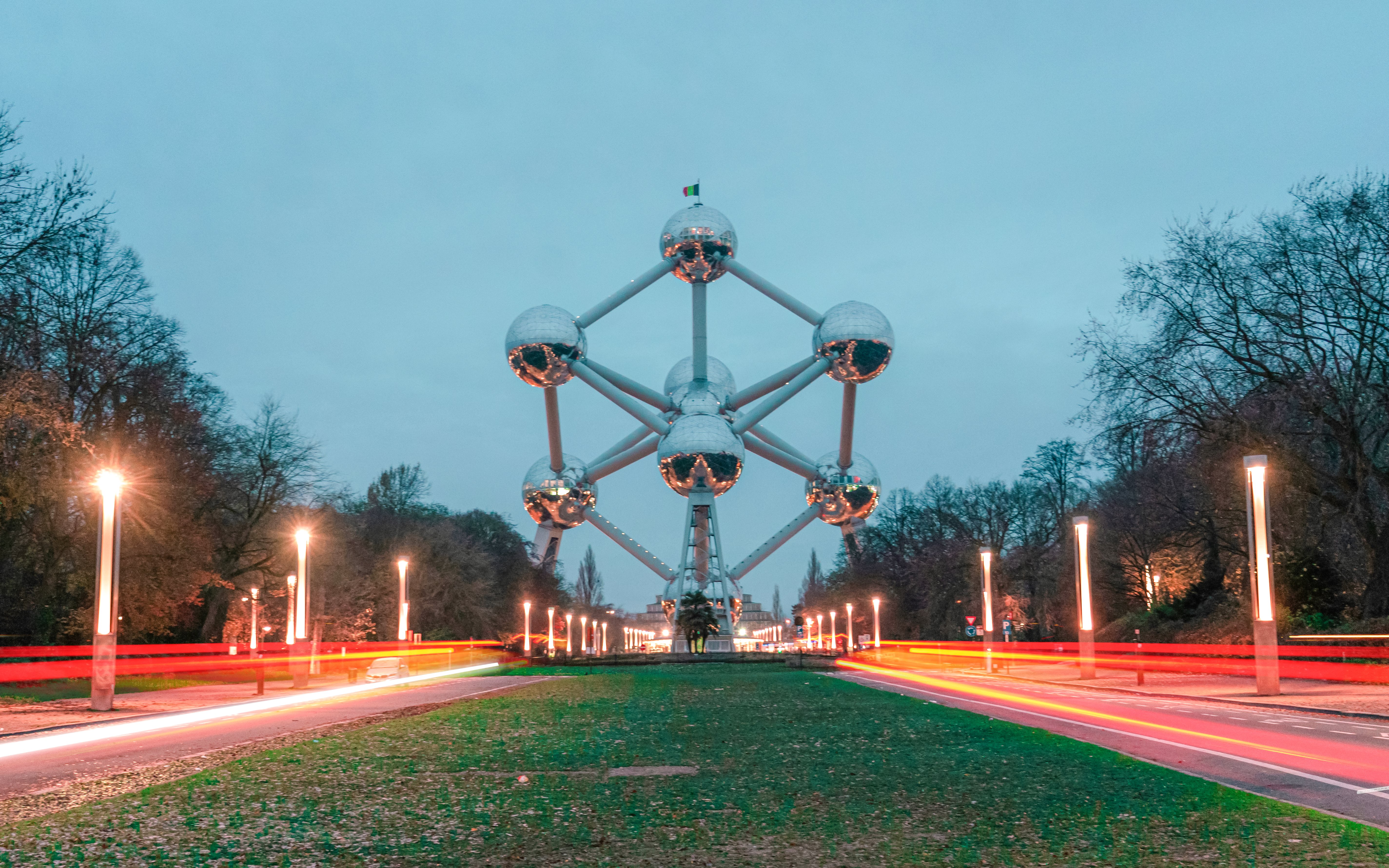 Atomium illuminated at night in Brussels with light trails on the road.