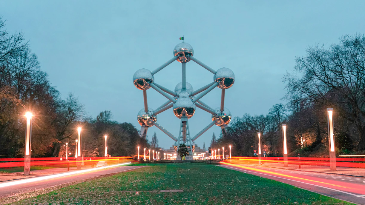 Atomium illuminated at night in Brussels with light trails on the road.