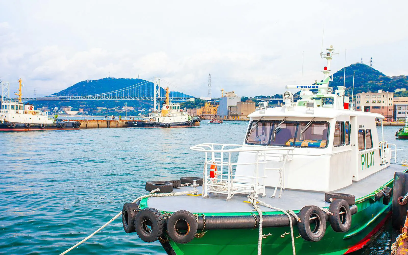 Large transport boat at Mojiko Port with Kanmonkyo Bridge in Kitakyushu, Japan.