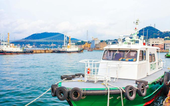 Large transport boat at Mojiko Port with Kanmonkyo Bridge in Kitakyushu, Japan.