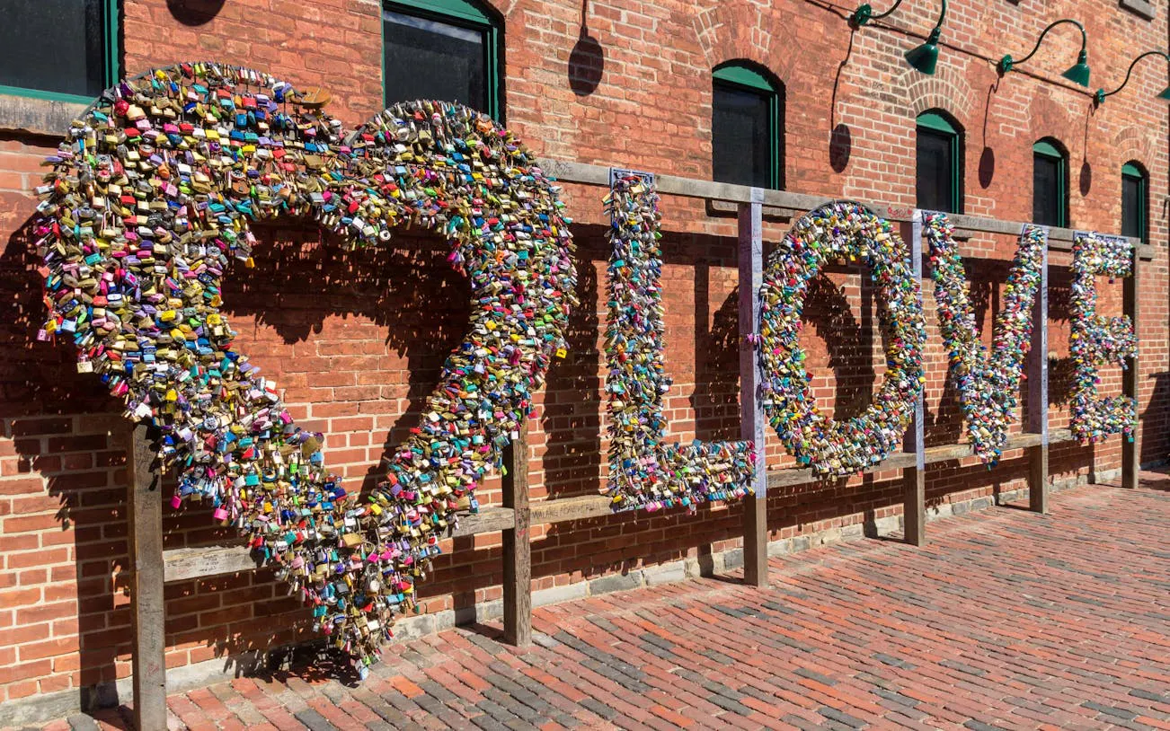 Love locks sculpture in Toronto's Distillery District on a brick wall.