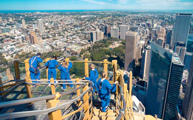 Visitors on Skywalk at Sydney Tower Eye overlooking cityscape.
