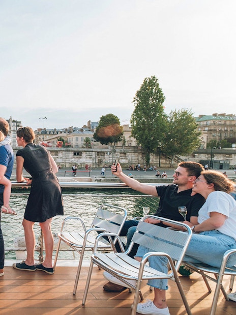 Family enjoying a Seine River cruise with a view of the Musée d'Orsay in Paris.