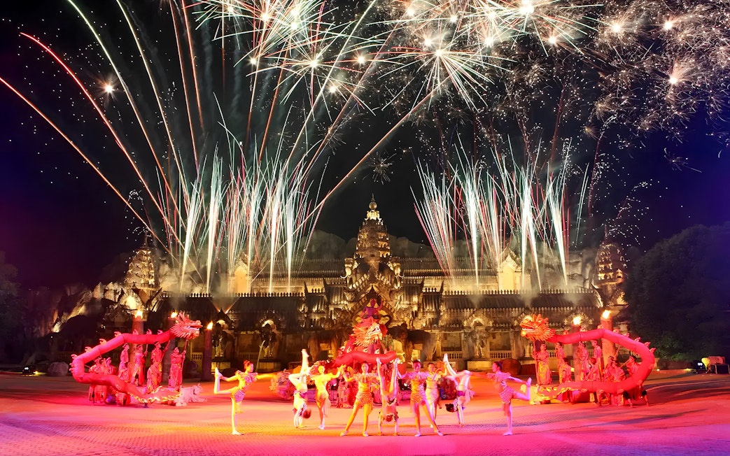 Fireworks over performers in Thai costumes dancing at Phuket Fantasea temple.