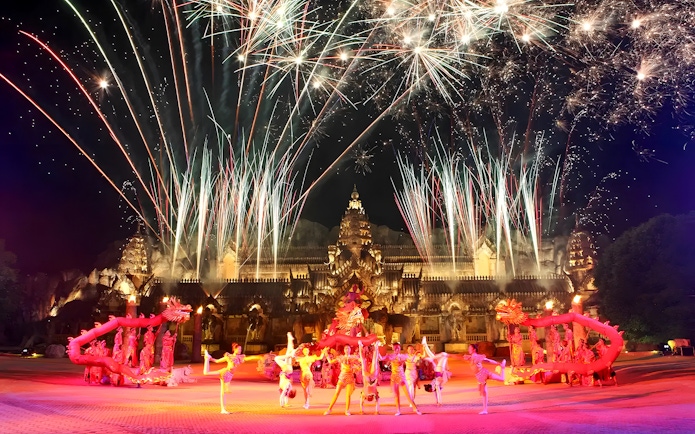 Fireworks over performers in Thai costumes dancing at Phuket Fantasea temple.