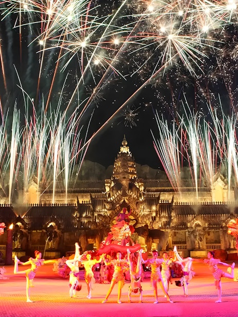 Fireworks over performers in Thai costumes dancing at Phuket Fantasea temple.