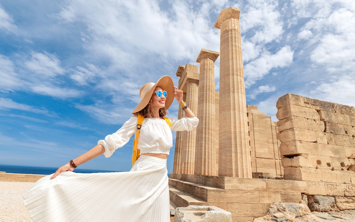 Tourist exploring the Acropolis of Athens with ancient columns in the background.