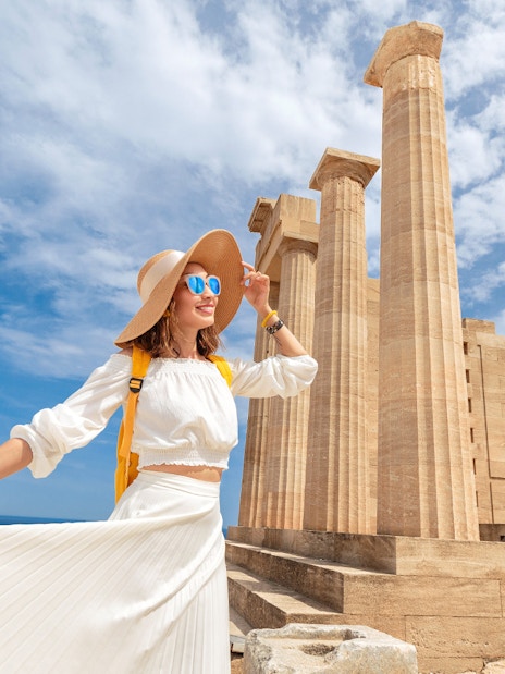 Tourist exploring the Acropolis of Athens with ancient columns in the background.