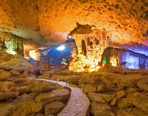 Halong Bay cave interior with illuminated stalactites on Dragonfly Cruise tour.