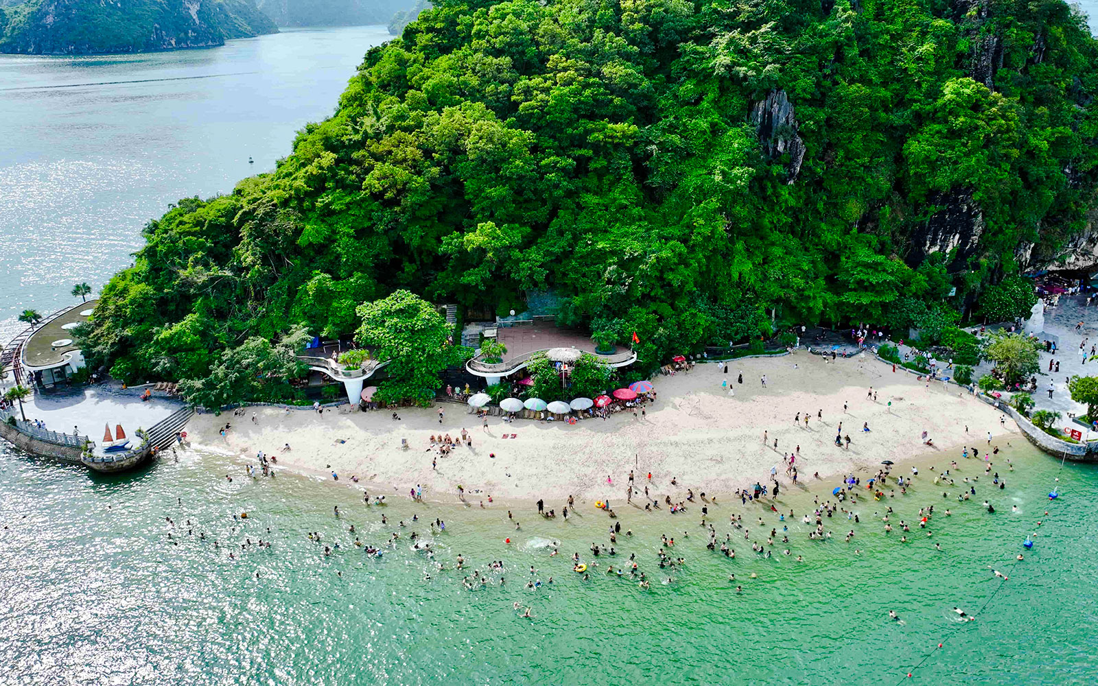 Aerial view of Titop Island beach with tourists swimming and relaxing.