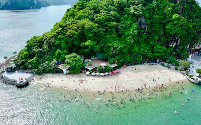 Aerial view of Titop Island beach with tourists swimming and relaxing.