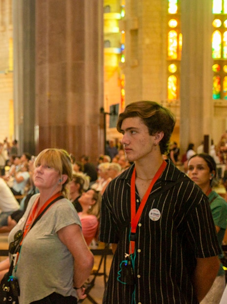 Tour guide explaining Sagrada Familia details to visitors in Barcelona.