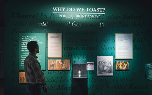 Visitor reading exhibit on toasting traditions at The Bridge Collection.
