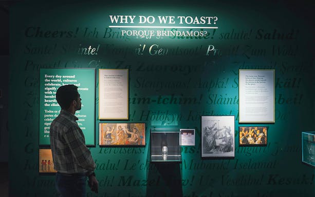 Visitor reading exhibit on toasting traditions at The Bridge Collection.