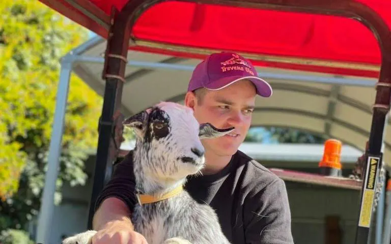 Man holding a goat during 1hr Premium Animal Tour in Brisbane.