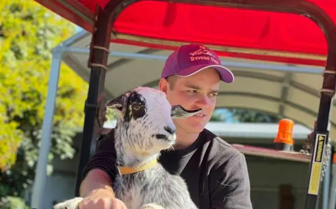 Man holding a goat during 1hr Premium Animal Tour in Brisbane.