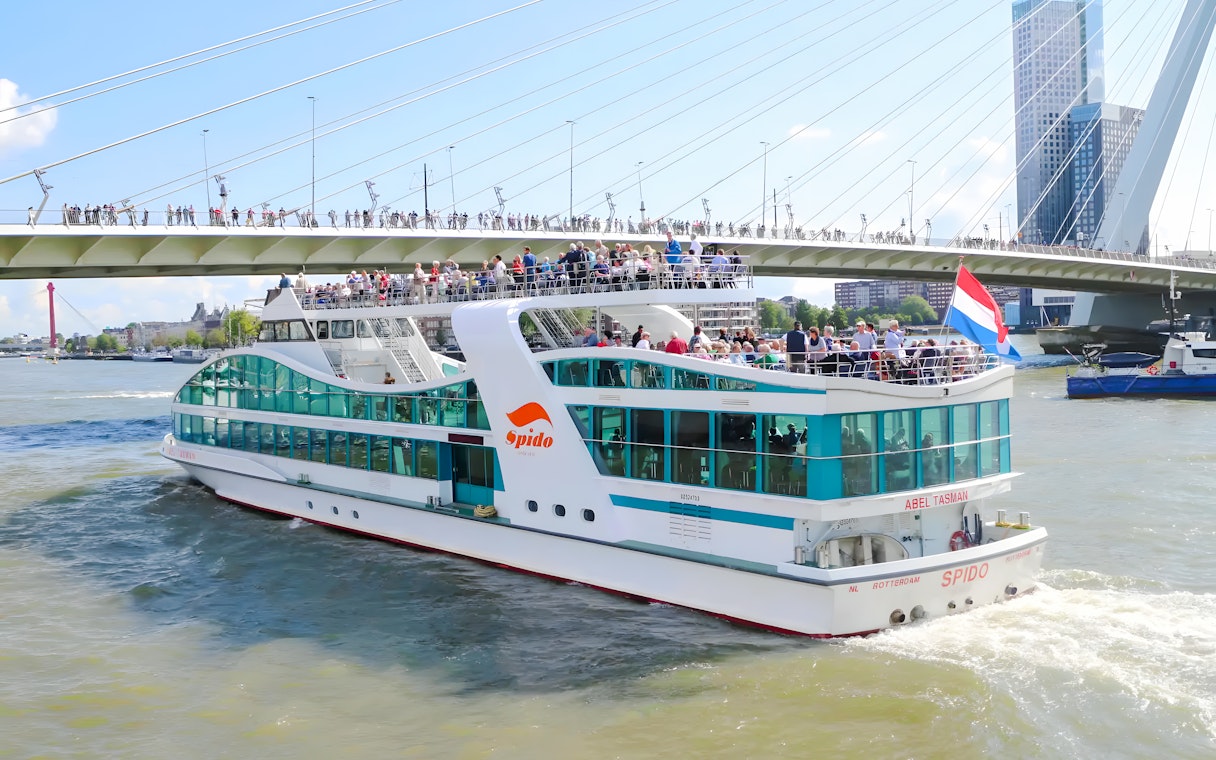Rotterdam harbor cruise ship passing under Erasmus Bridge.