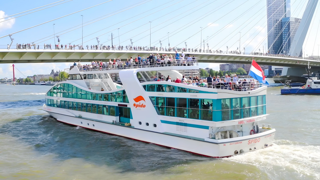 Rotterdam harbor cruise ship passing under Erasmus Bridge.
