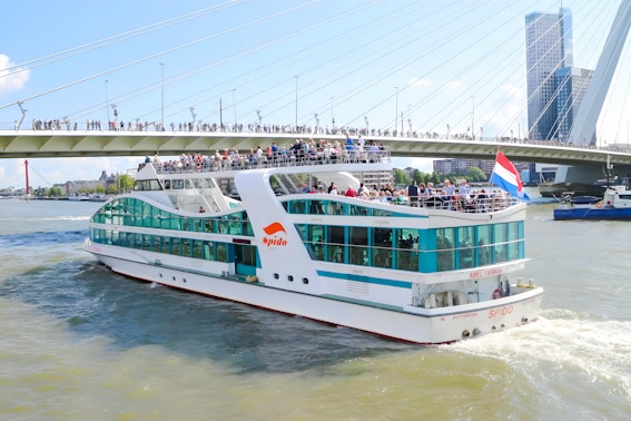 Rotterdam harbor cruise ship passing under Erasmus Bridge.