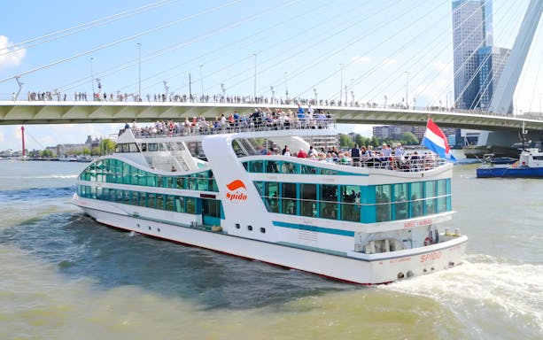 Rotterdam harbor cruise ship passing under Erasmus Bridge.