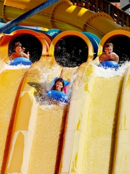 Riders on Wahoo Racer water slide at Hurricane Harbor, Six Flags Chicago.
