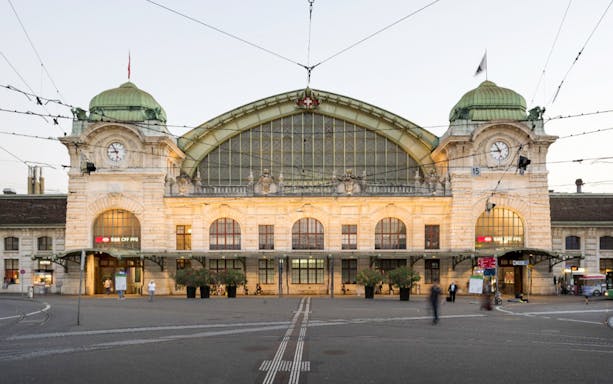 Basel Train Station facade with clock and tram lines, connecting to Euro Airport.