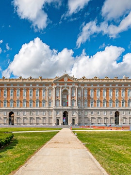 Royal Palace of Caserta facade with blue sky and clouds in Caserta, Italy.