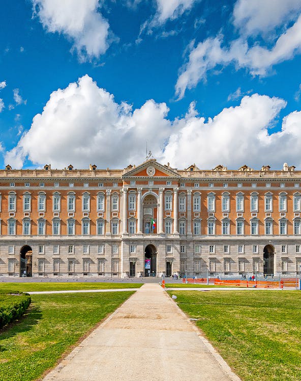 Royal Palace of Caserta facade with blue sky and clouds in Caserta, Italy.